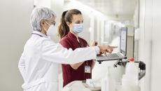 Healthcare professionals standing at a computer