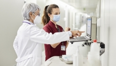 A doctor and a nurse using a computer together in a hospital.