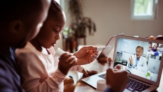 Adult and child talking to a provider through a video chat