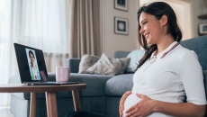 A pregnant person talking to a provider on a tablet