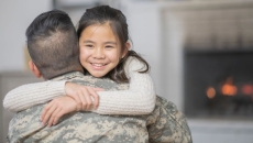 Military serviceman hugging another person