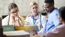 Healthcare professionals looking at a tablet
