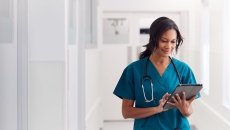 A doctor checking a patient's record on a digital tablet