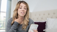 A person talking on a video chat on a phone about a sore throat
