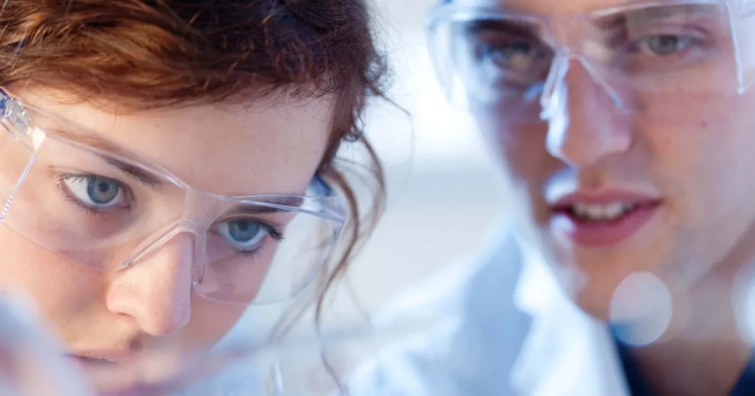 Two healthcare professionals wearing safety goggles