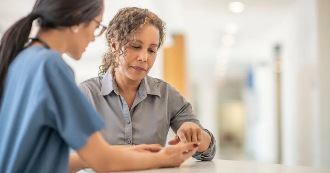 A healthcare provider speaking to an individual in a clinical setting