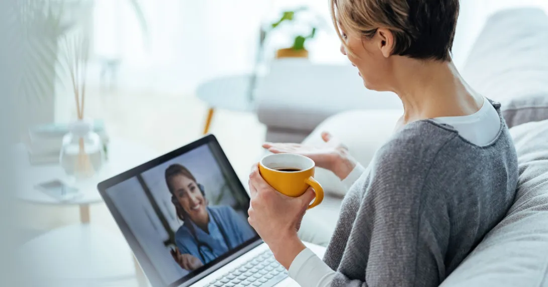 
  Person sitting on a couch with a laptop on a telehealth video call
