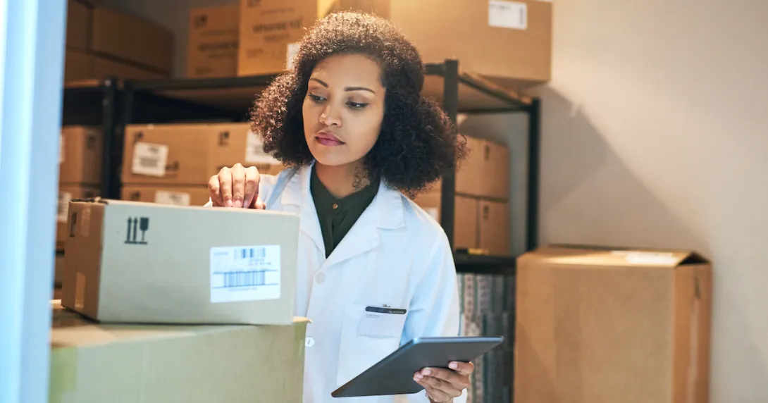 A person using a digital tablet while doing inventory in the storeroom of a pharmacy
A person using a digital tablet while doing inventory in the storeroom of a pharmacy