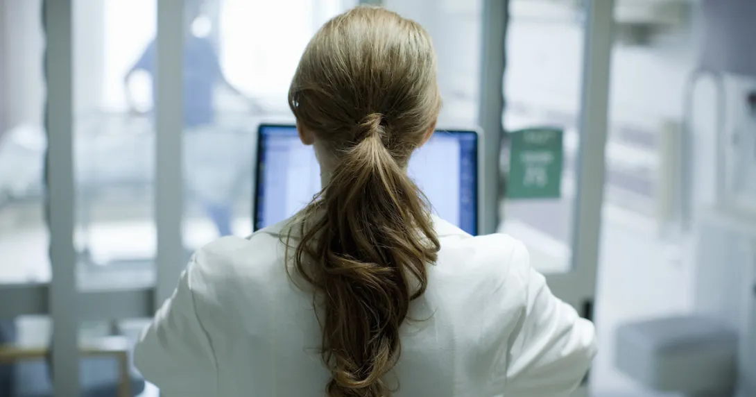 
  Person sitting at a computer with their back turned
