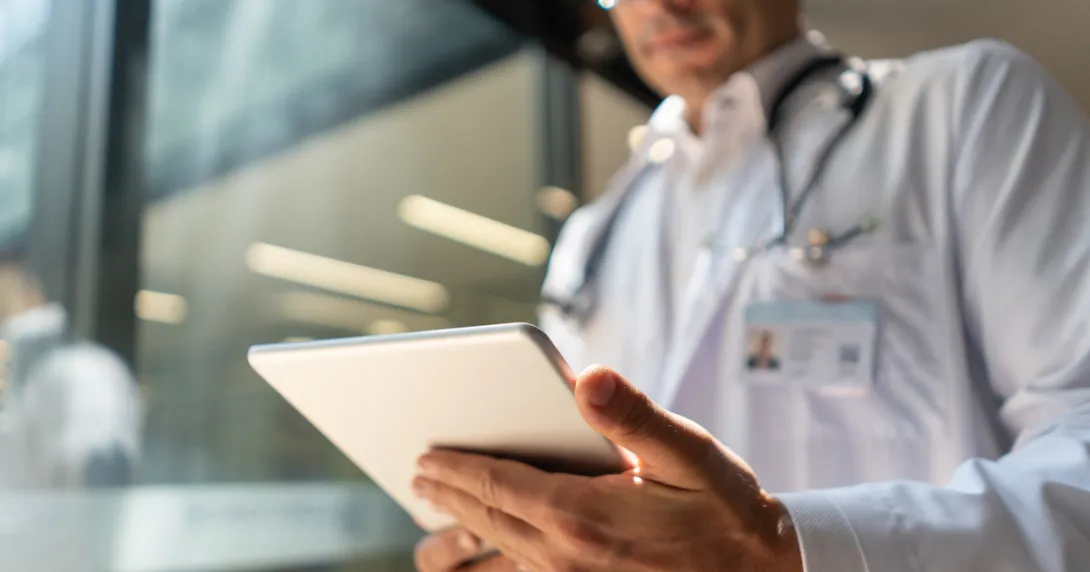 A doctor reviewing a patient's file on a digital tablet