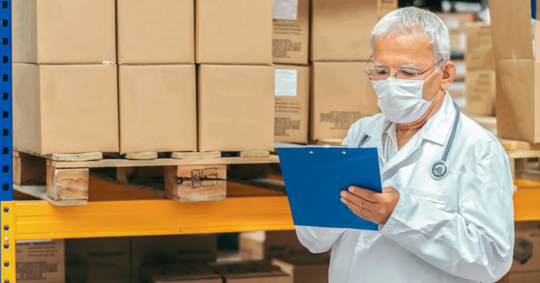 
  Healthcare provider looking at a document with boxes behind them
