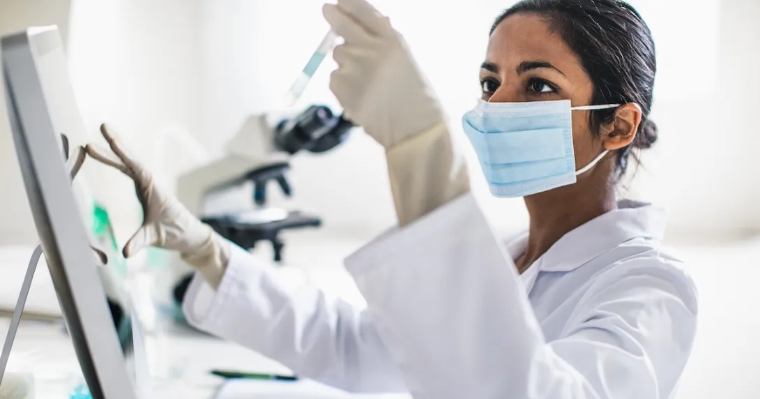 Lab technician examining contents of a test tube