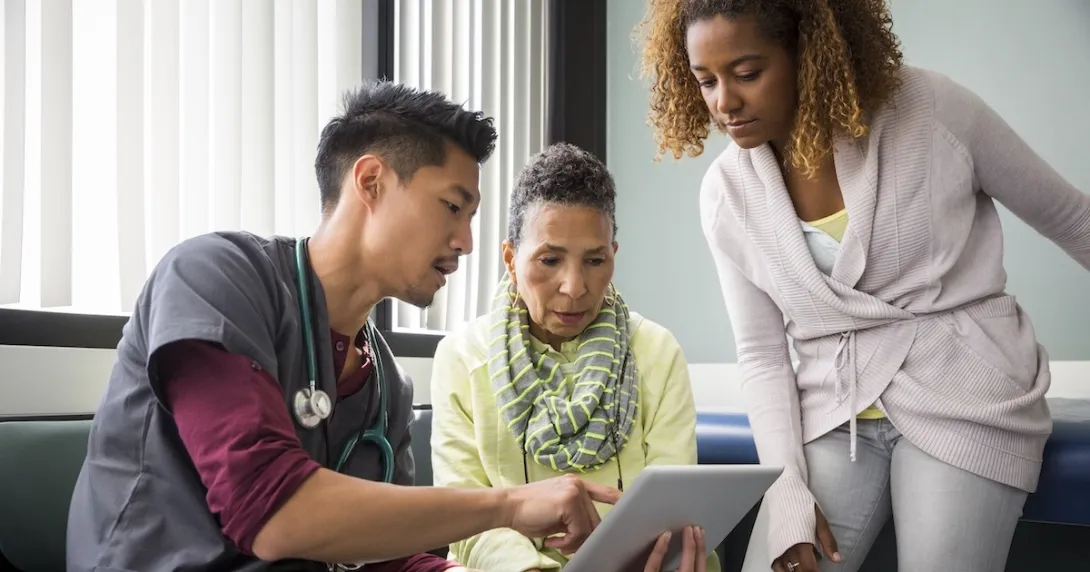 Healthcare professional review patient chart with two people