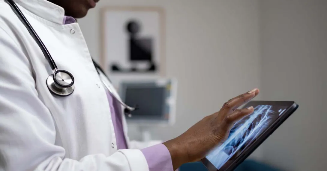 
  Healthcare provider looking at x-ray images on a tablet
