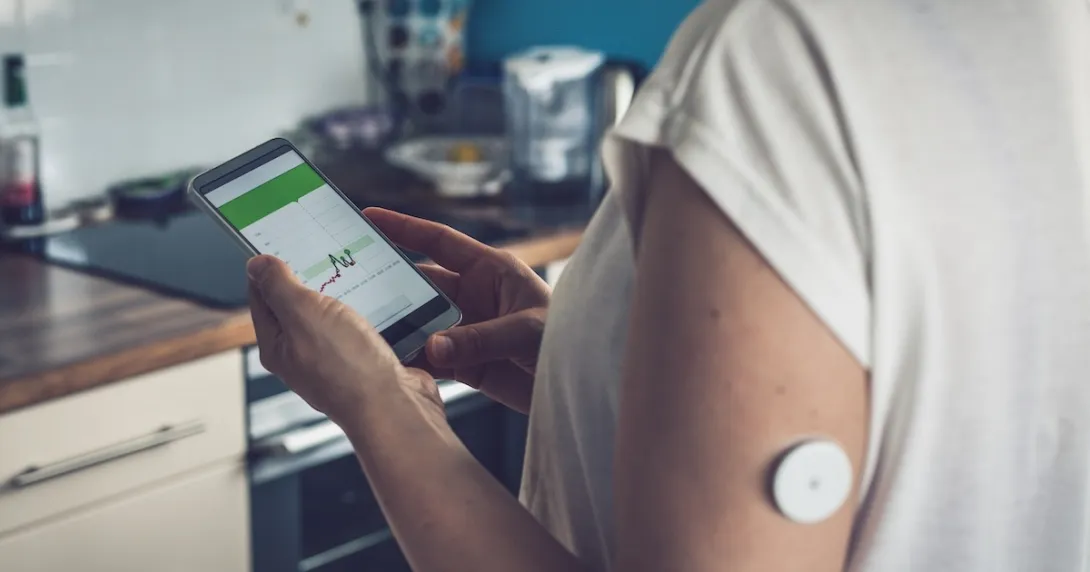 Image of person with glucose patch looking at a smartphone