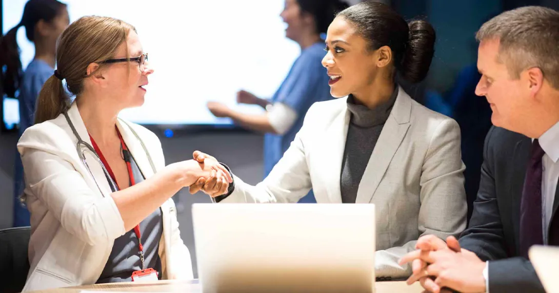 Businesspeople shaking hands in front of a laptop
Businesspeople shaking hands in front of a laptop