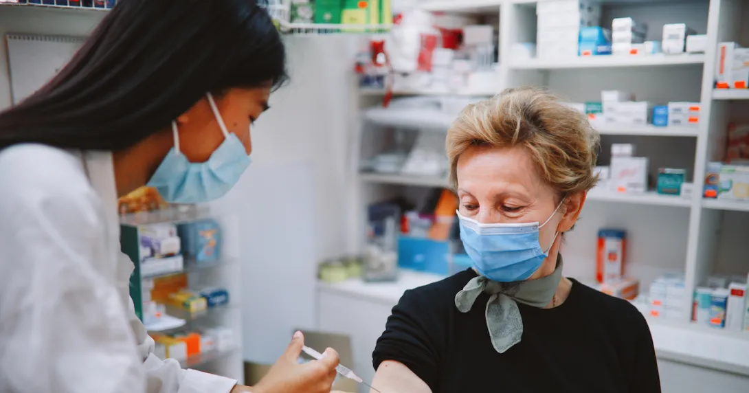 
  A person getting a vaccine at a pharmacy.
