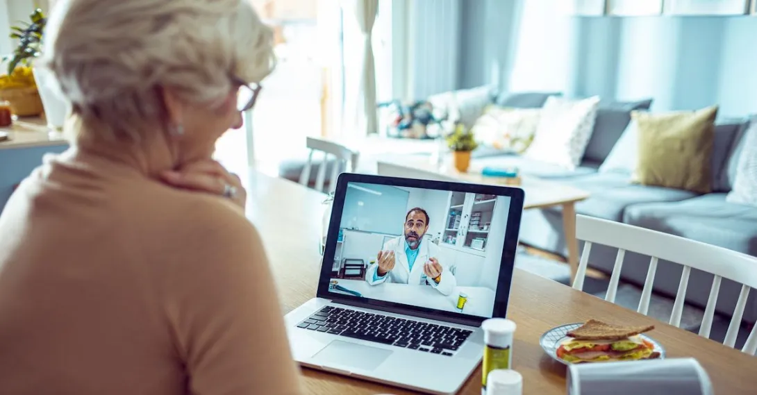 
  A person talking to a doctor via video call on her laptop.
