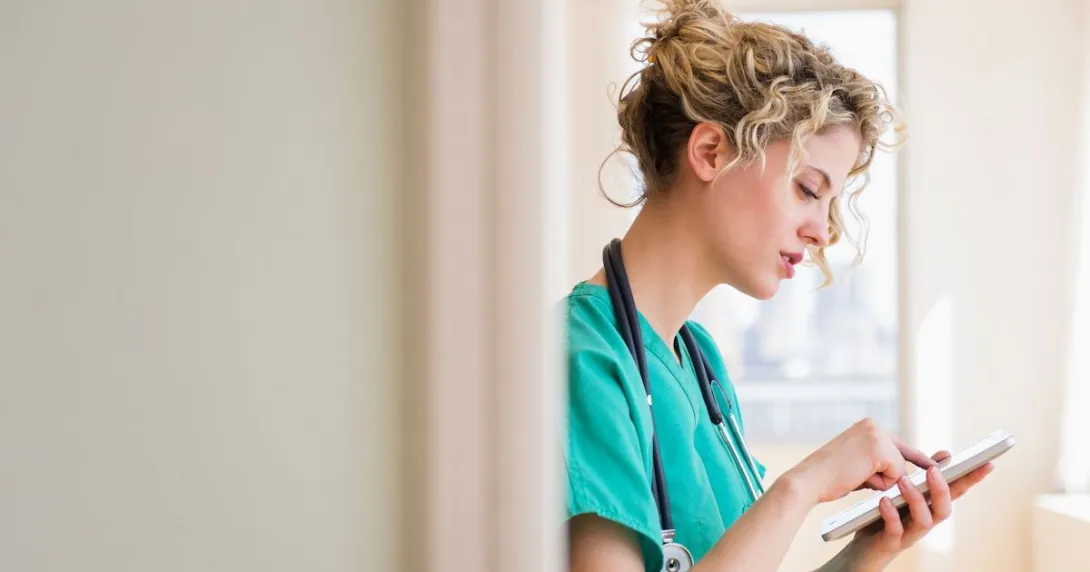 A nurse checking on tasks in their device
