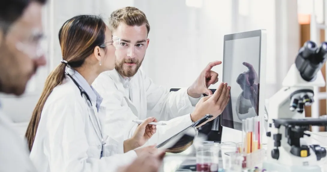 
  Healthcare providers in a laboratory looking at a computer
