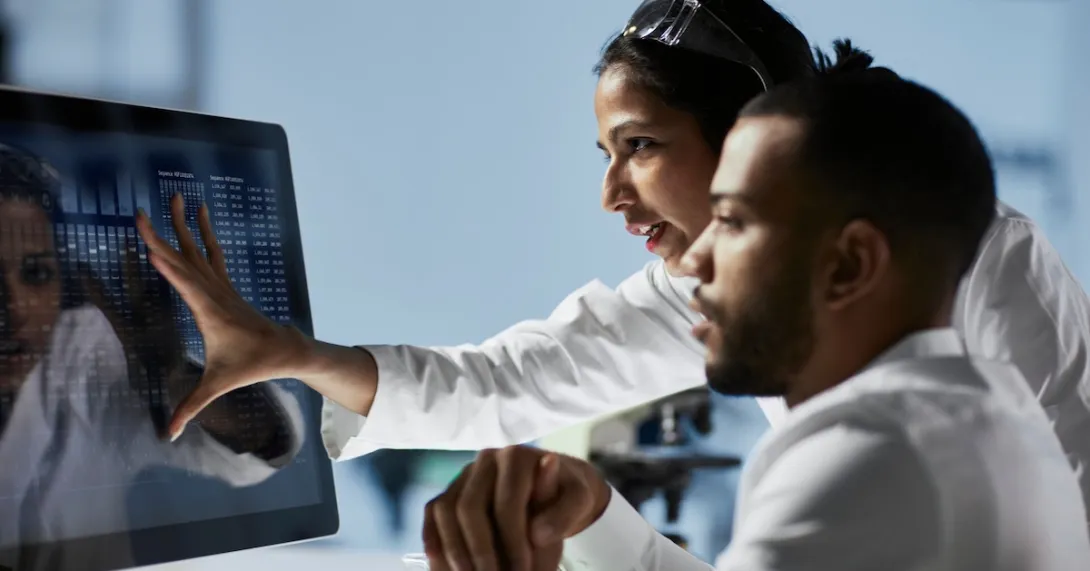 Two healthcare providers looking at a computer screen Two healthcare providers looking at a computer screen