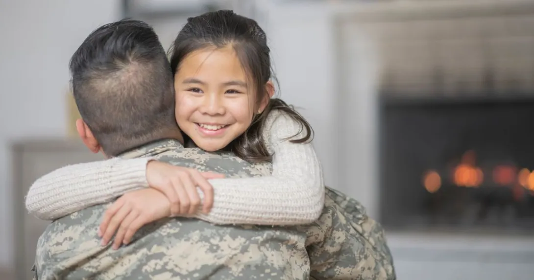 
  Military serviceman hugging another person 
