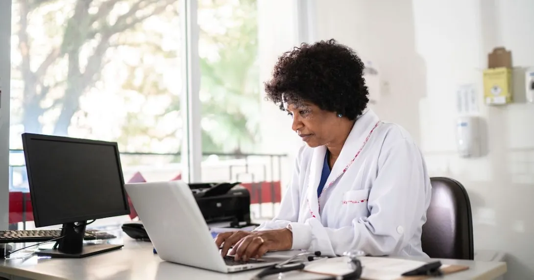 
  Healthcare provider sitting at a desk and looking at a computer

