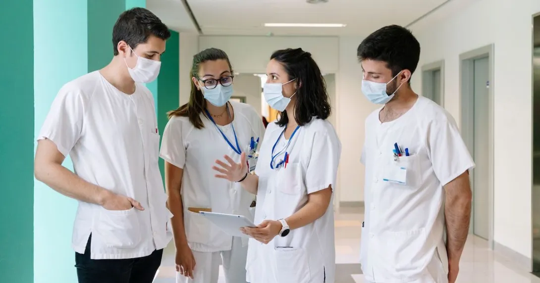 
  Healthcare workers standing in a hallway talking
