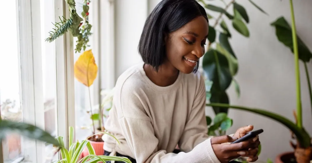 Person sitting in a chair and surrounded by plants while looking at a phone
Person sitting in a chair and surrounded by plants while looking at a phone