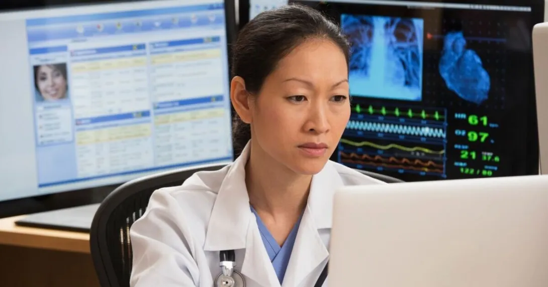 A doctor reviewing a patient's record on a laptop computer