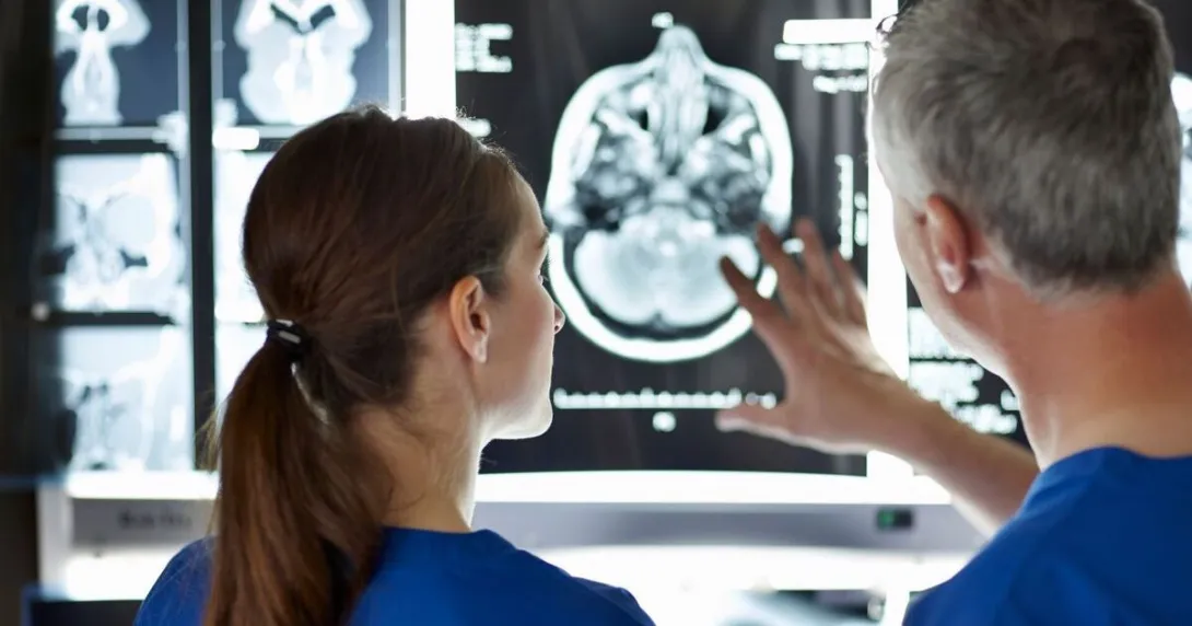 Two surgeons examining a brain scan