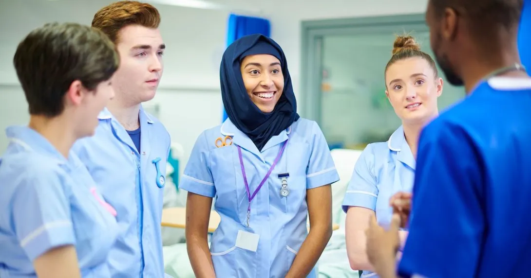 Medical students chatting with their manager during a break after doing their rounds