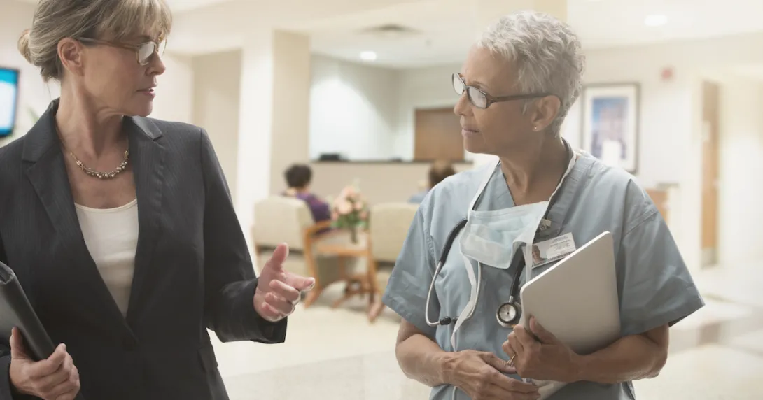 Business person and healthcare provider walking together