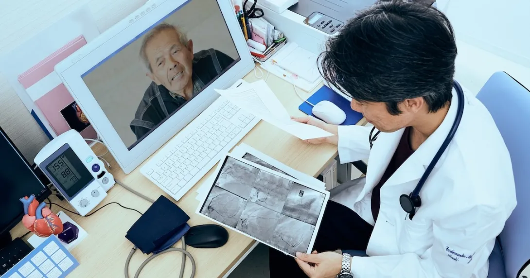 Doctor consulting with patient via computer Doctor consulting with patient via computer
