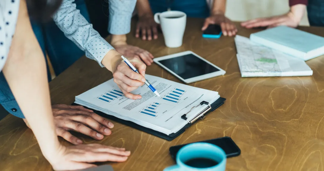 A close up of workers analyzing financial charts