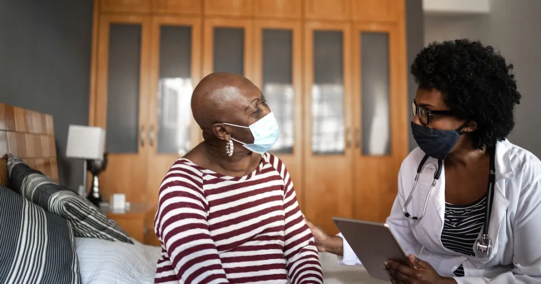 A woman chats with a clinician in her home