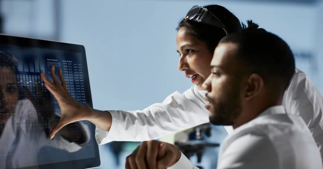 Doctors looking at patient data on a monitor