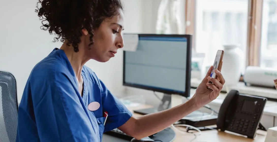A doctor talking to a patient through a video call on her smartphone