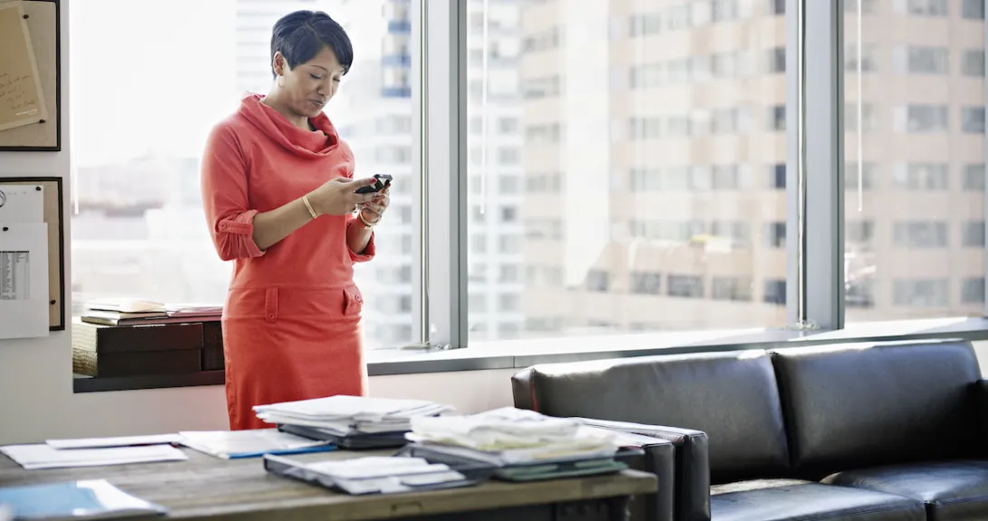 A person using a smartphone at her desk.