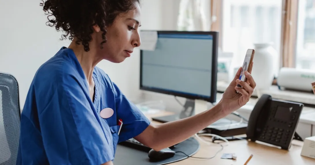 Healthcare professionals interacting with a person on a cell phone Healthcare professionals interacting with a person on a cell phone